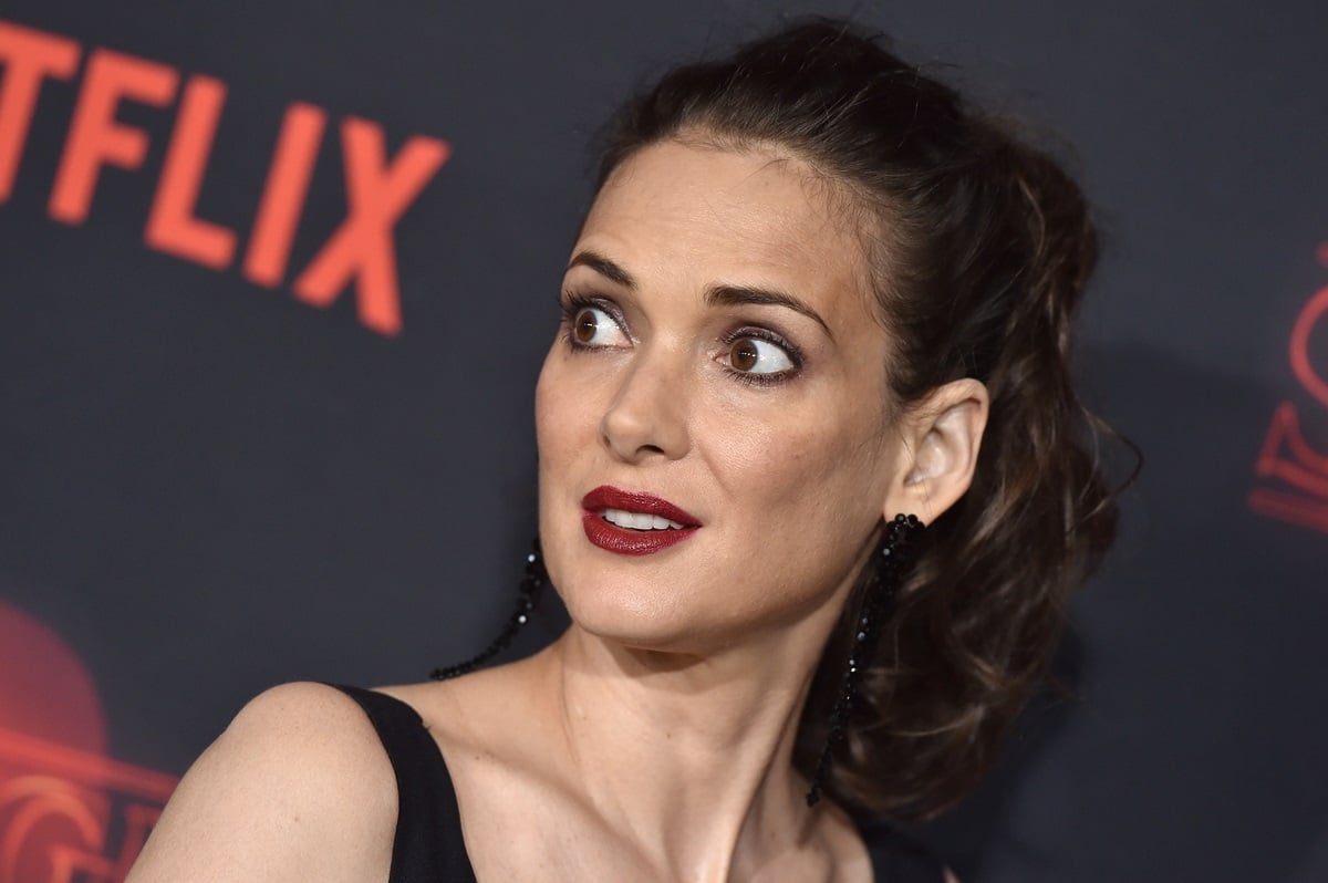 Winona Ryder posing in a black dress at the 'Stranger Things' premiere.