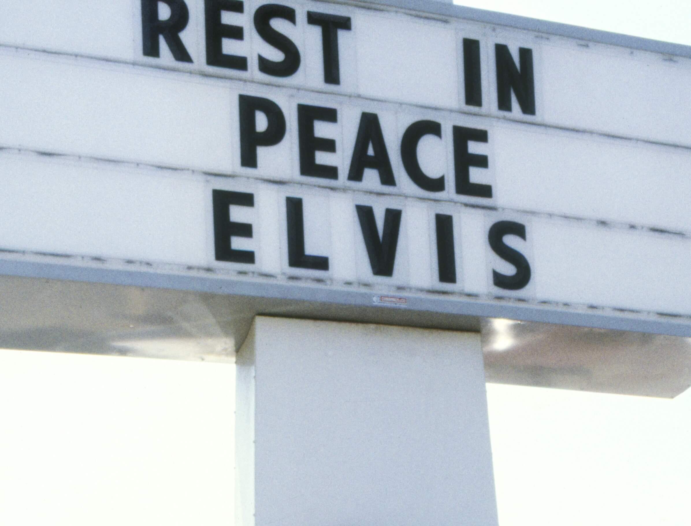 A sign reading "Rest in Peace Elvis"