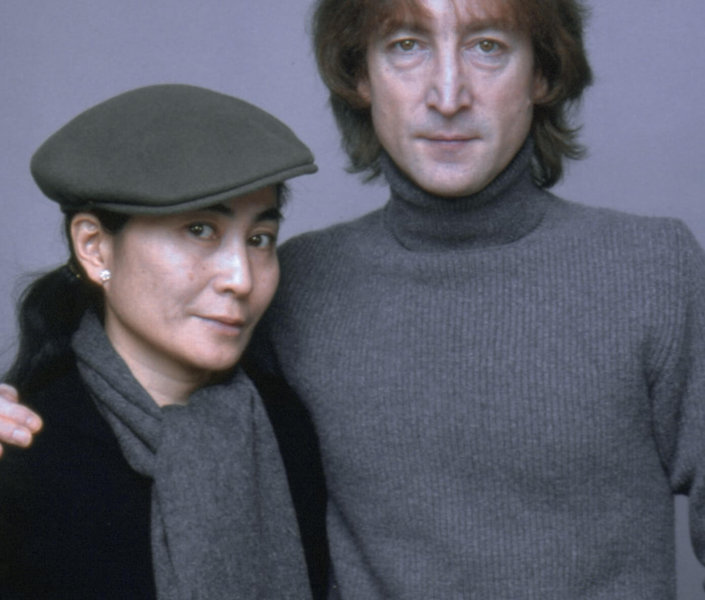 Yoko Ono and John Lennon in front of a gray background