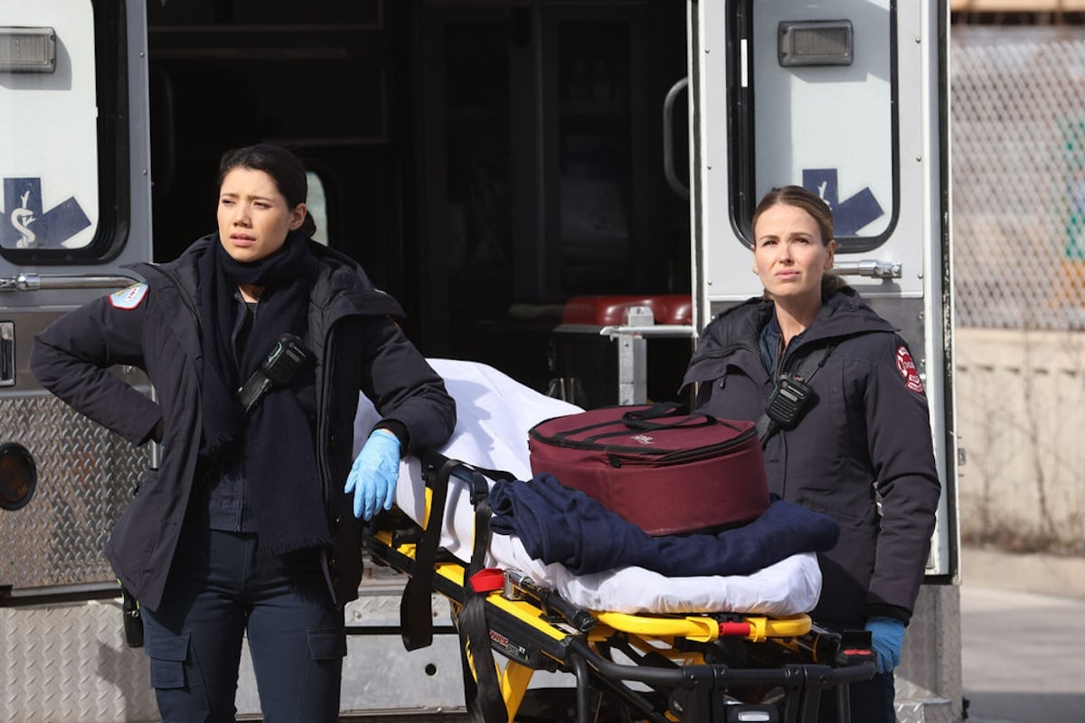Hanako Greensmith and Jocelyn Hudon standing next to a stretcher in an episode of 'Chicago Fire' Season 12