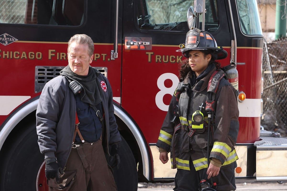 Two firefighters standing in front of a fire truck in an episode of 'Chicago Fire'