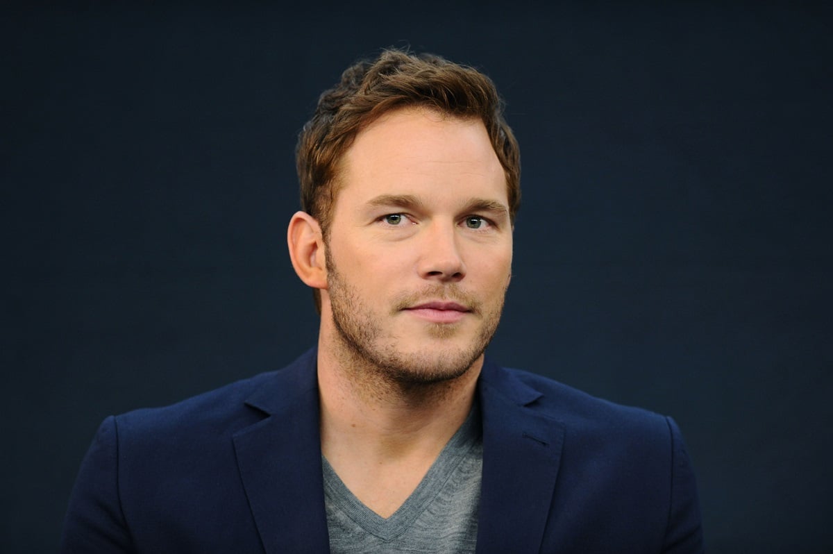 Chris Pratt posing at the Meet the FilmMakers event for "Guardians of the Galacy" while wearing a suit.