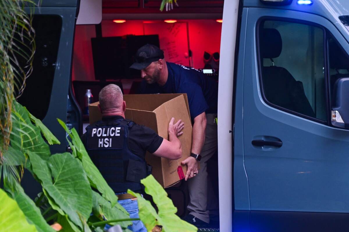 Agents load a box into a car at the entrance of US producer and musician Sean "Diddy" Combs's home at Star Island