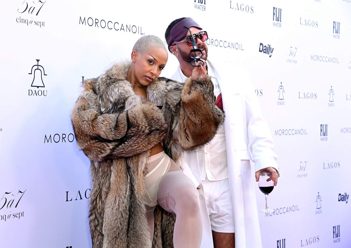 Rapper/singer Doja Cat and Brett Alan Nelson laugh together on the red carpet as they hold glasses of wine