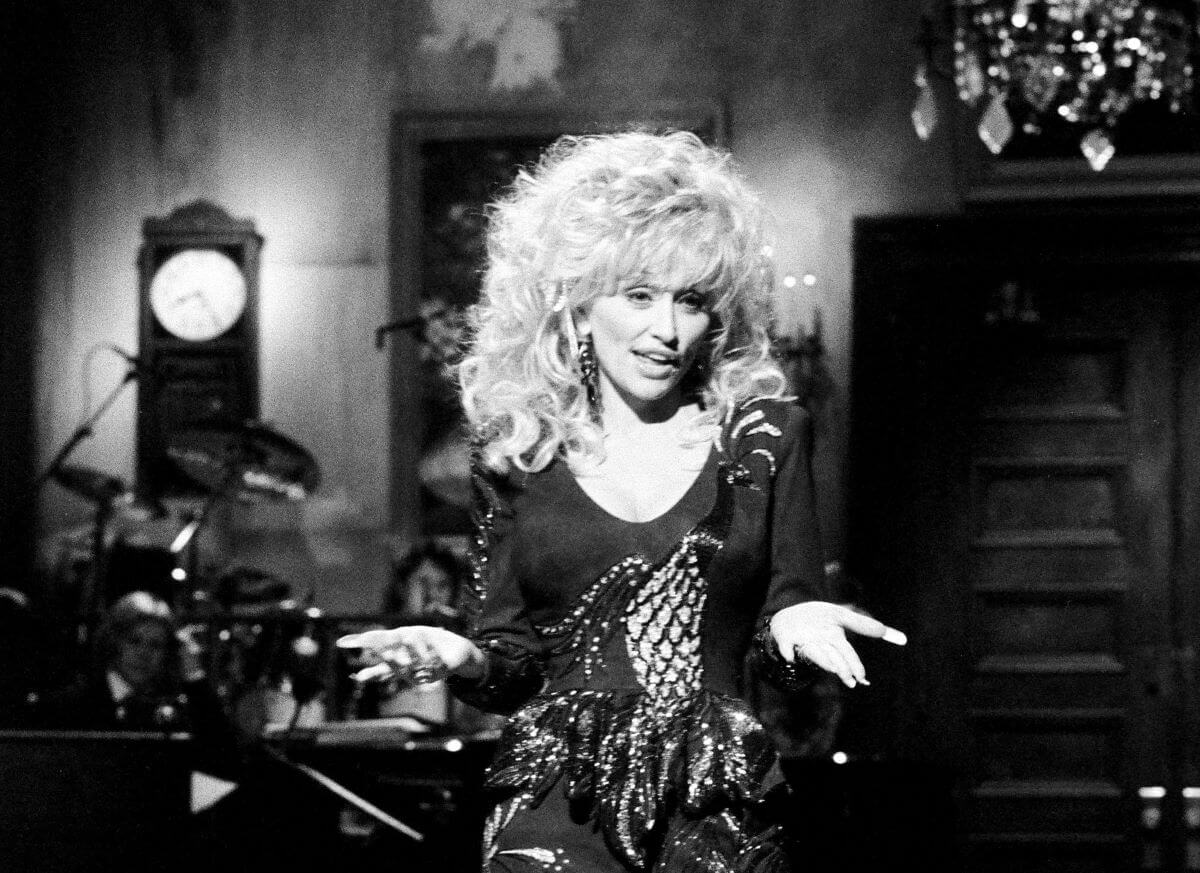 A black and white picture of Dolly Parton wearing a dress during her Saturday Night Live appearance.