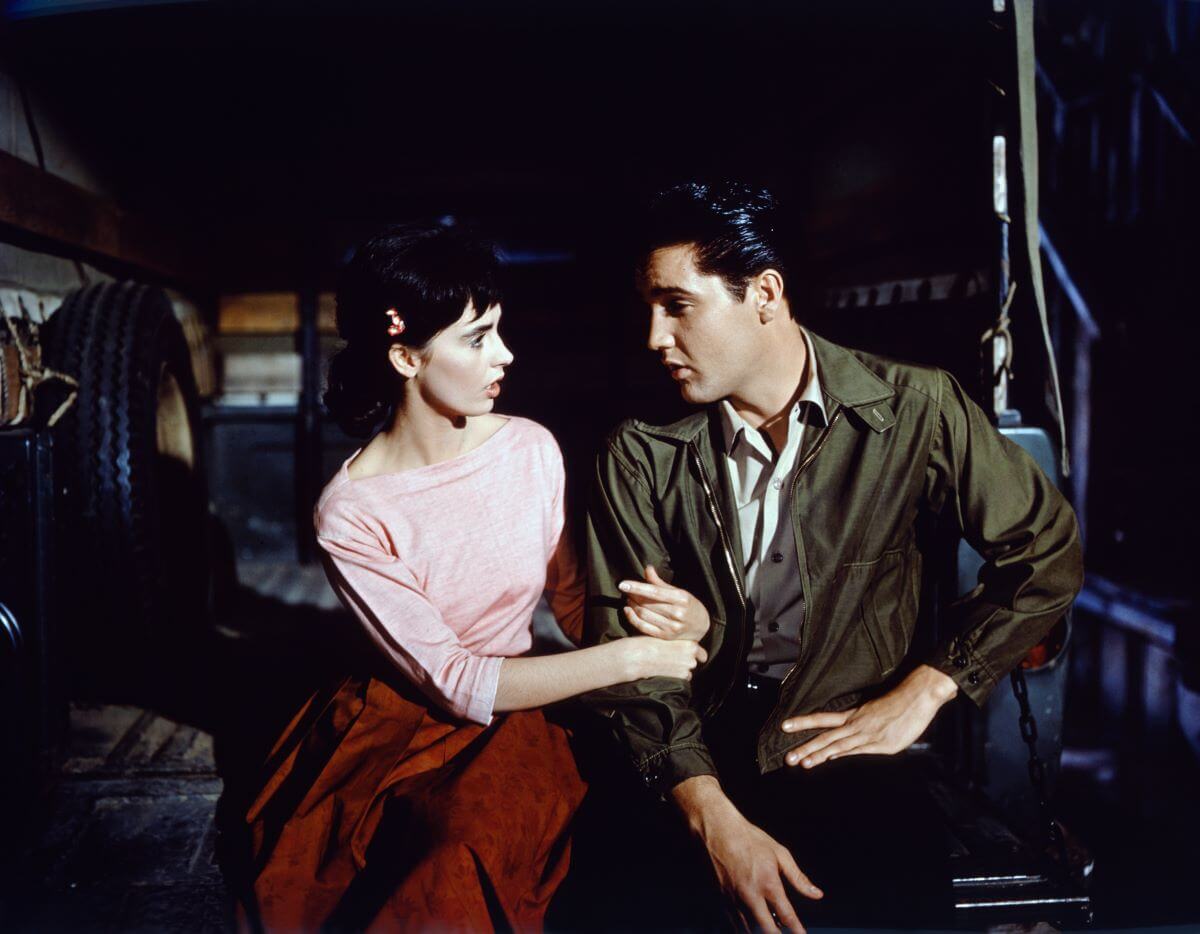 Millie Perkins sits with her hands around Elvis Presley's arm in 'Wild in the Country.'
