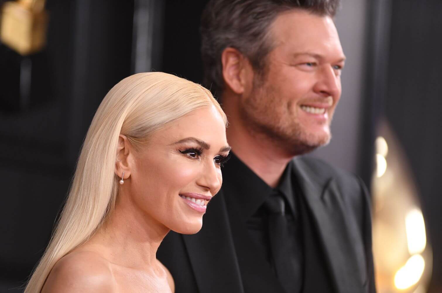 A close-up of Gwen Stefani and Blake Shelton standing next to each other and smiling at an event