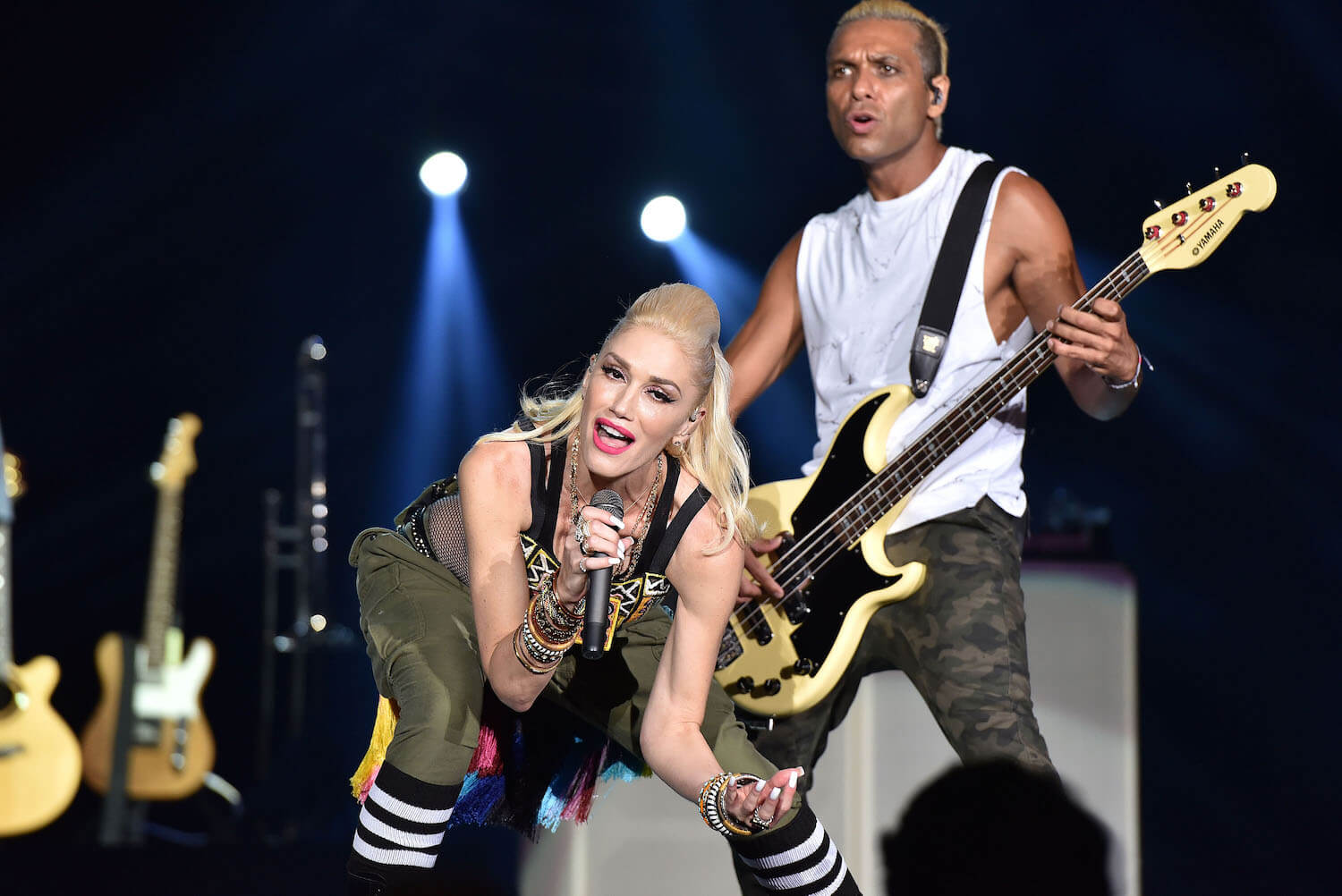 Gwen Stefani singing on stage in front of No Doubt bassist Tony Kanal in 2015