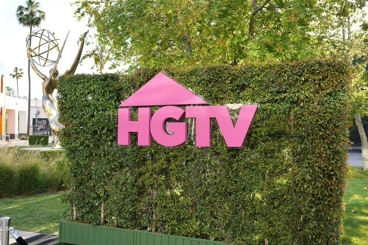 HGTV logo in pink on a green hedge