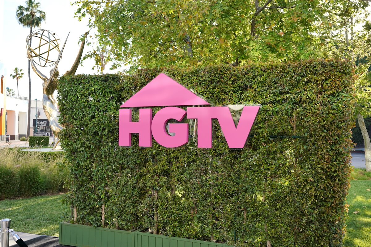 HGTV logo in pink on a green hedge