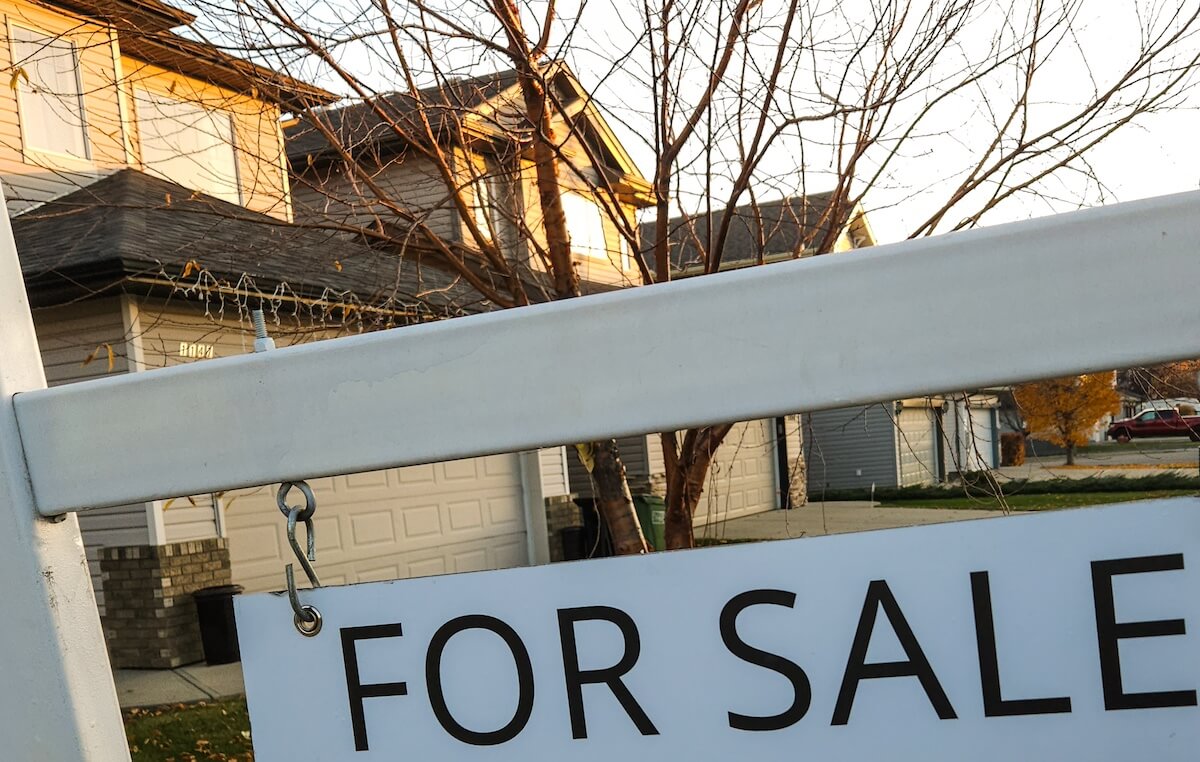 For sale sign outside of a suburban home