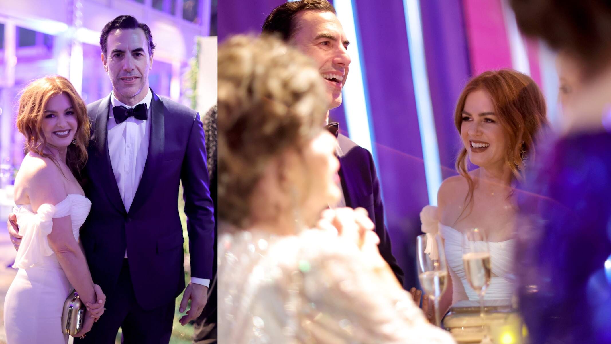 In a white dress and tuxedo respectively, Isla Fisher and Sacha Baron Cohen laugh together at the 2022 Vanity Fair Oscar Party