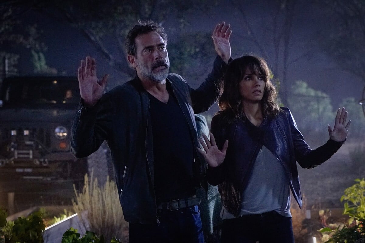 Jeffrey Dean Morgan and Halle Berry both standing with their hands up in an episode of 'Extant'.