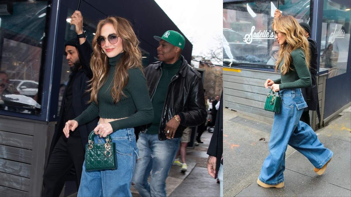 Singer Jennifer Lopez walks across an NYC street in baggy jeans and a green top, showing her abs