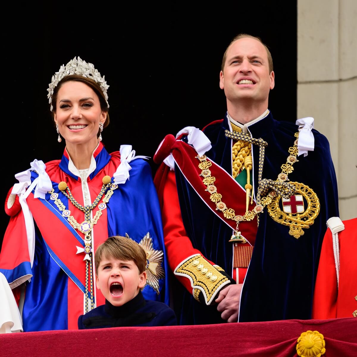 Kate Middleton, Prince Louis, and Prince William standing on the balcony of Buckingham Palace during the Coronation of King Charles III