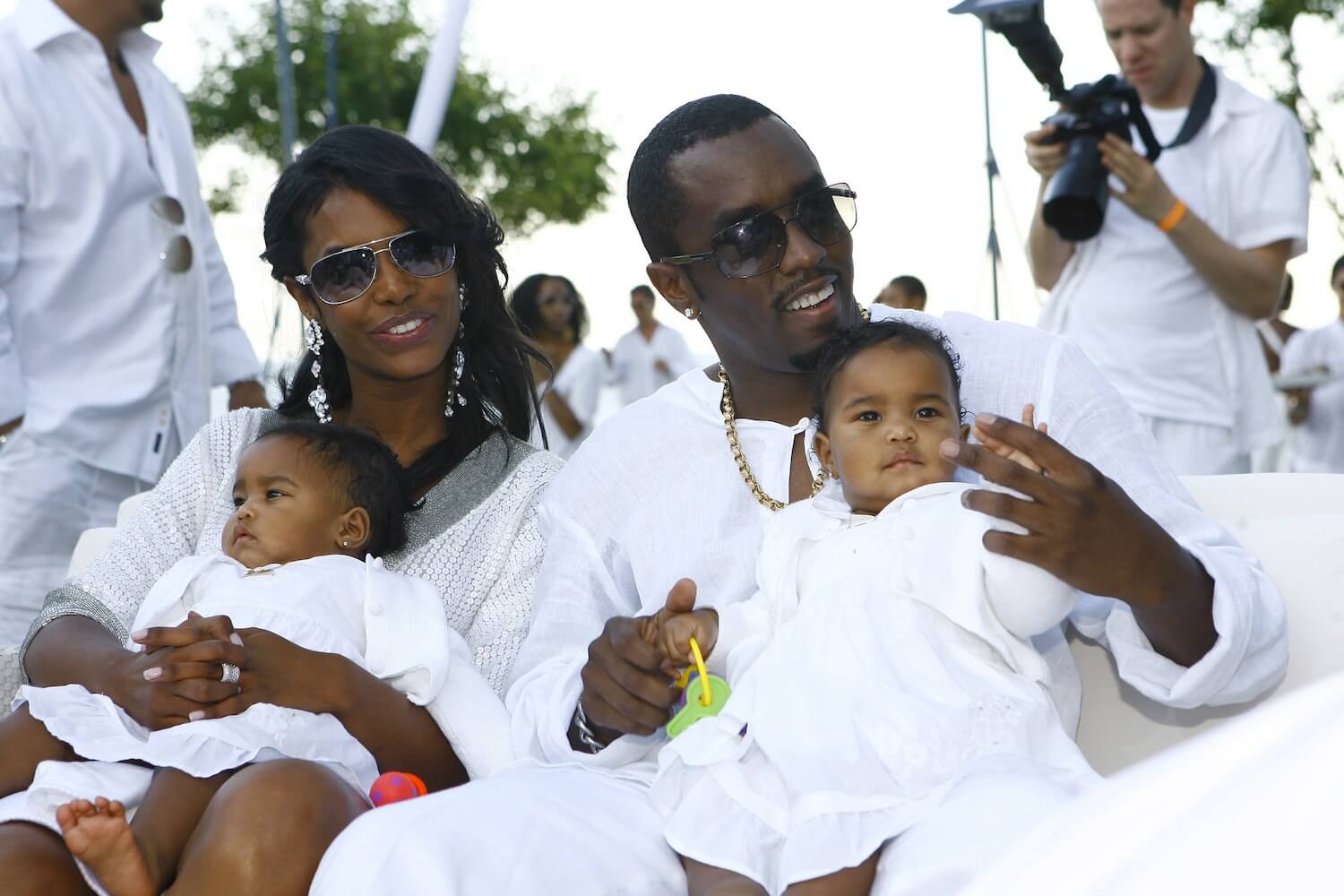 Kim Porter and Sean 'P. Diddy' Combs dressed in white while holding their infant twin daughters