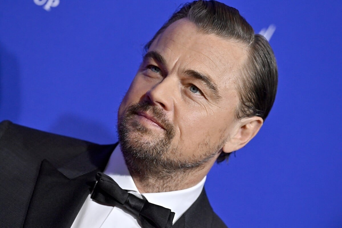 Leonardo DiCaprio posing at the 2024 Palm Springs International Film Festival Film Awards in a suit.