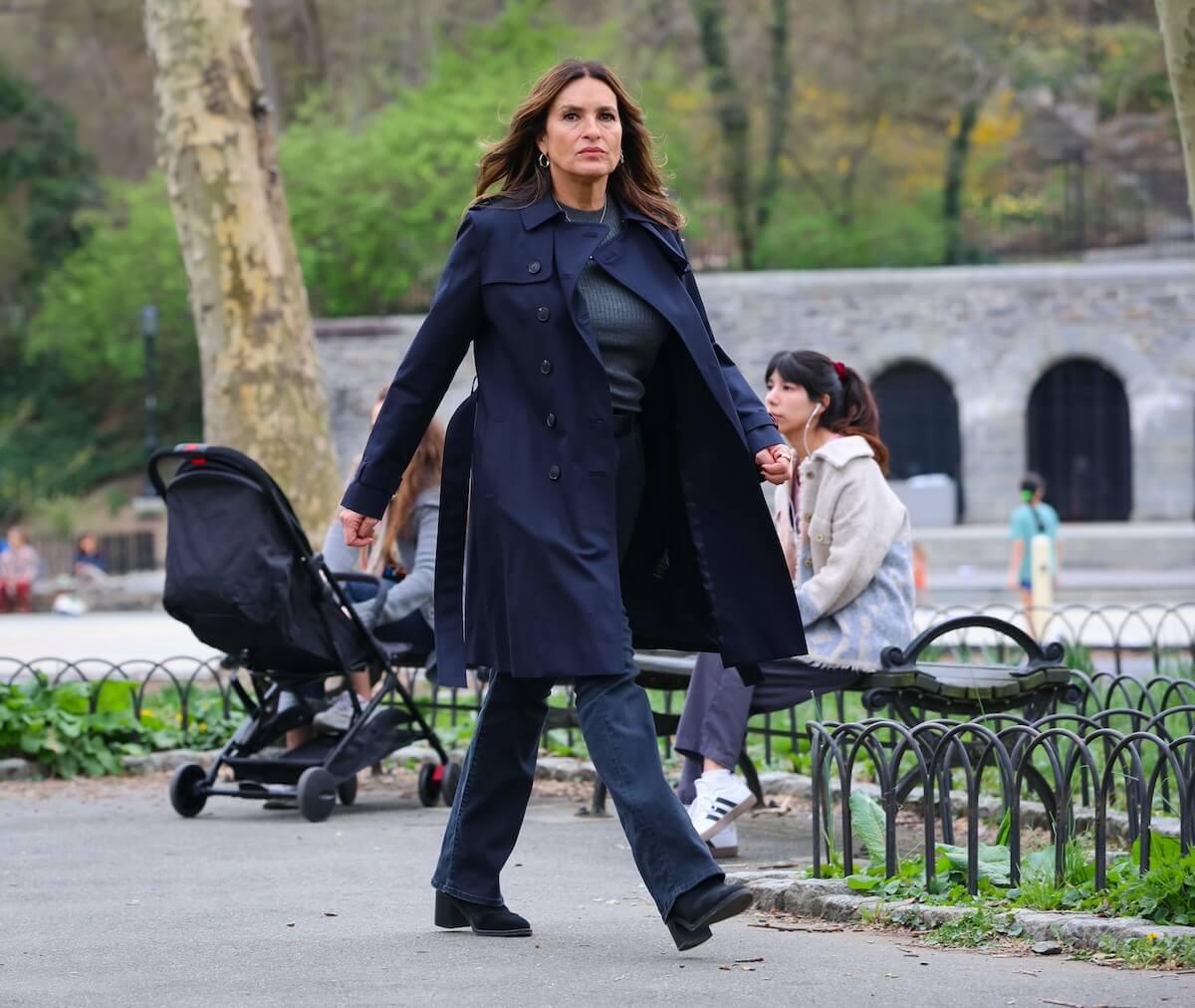 Mariska Hargitay, dressed in black, walks in a park while filming an episode of 'Law and Order: SVU'