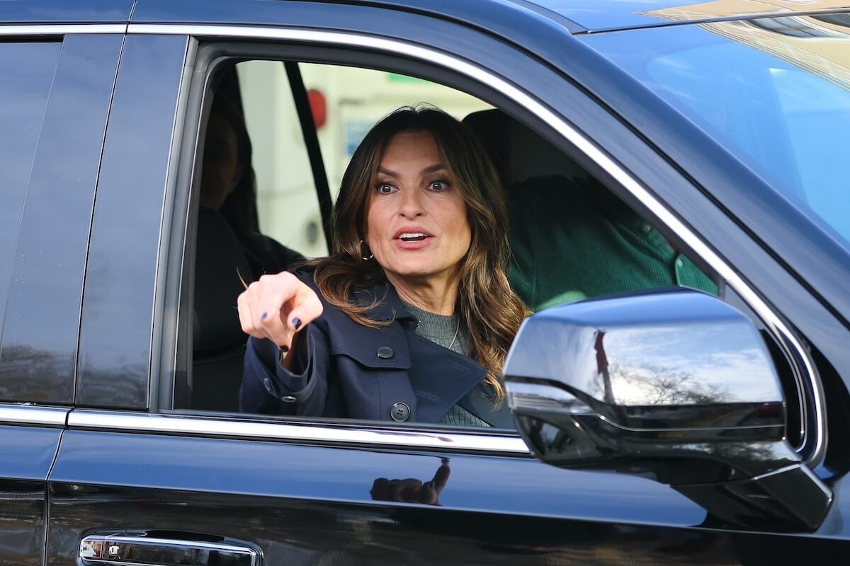 Mariska Hargitay sitting in a car and pointing out the window