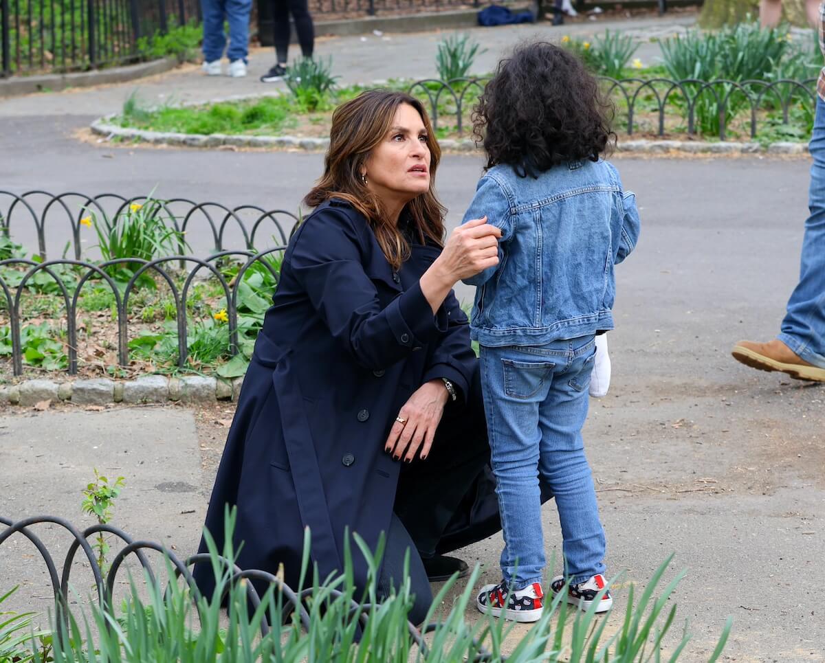 Mariska Hargitay crouches down while talking to a little girl