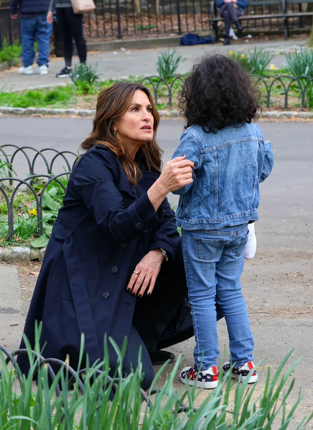 Mariska Hargitay crouches down while talking to a little girl