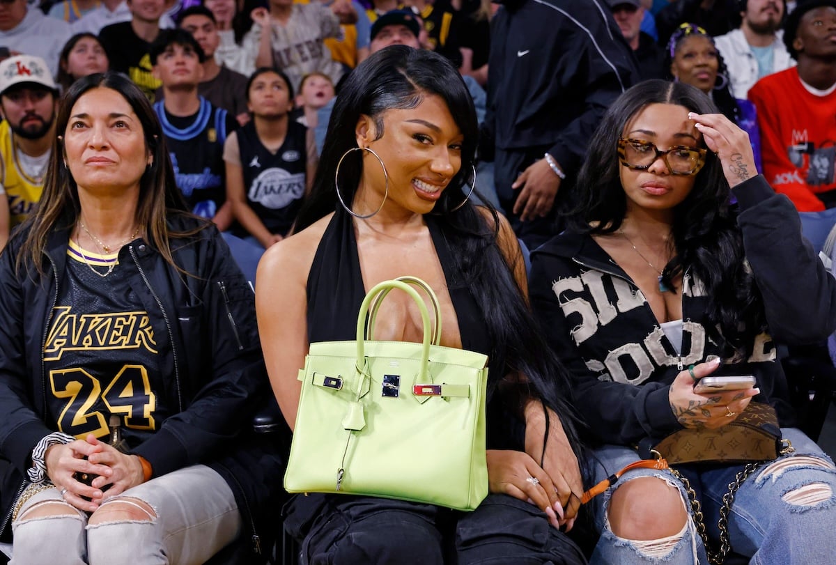 Rapper Megan Thee Stallion, holding her Birkin bag, attends a Lakers game