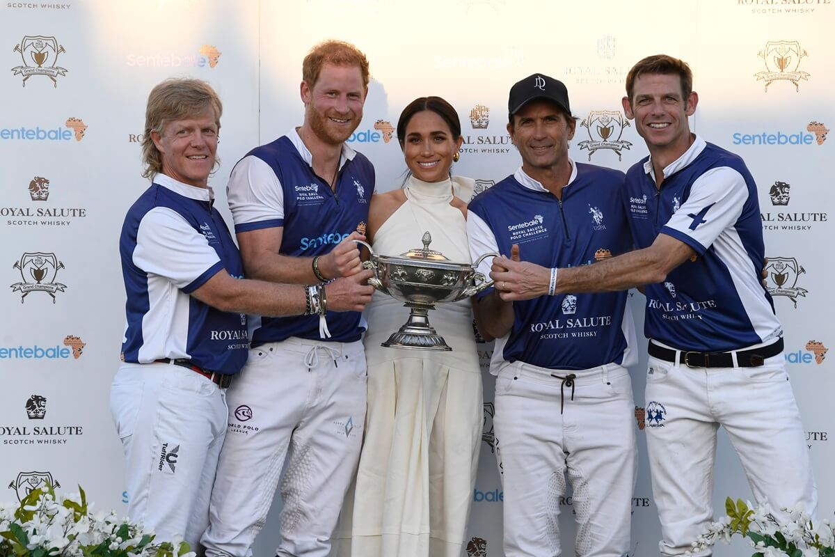 Meghan Markle and Prince Harry posing with the duke's teammates during the Royal Salute Polo Challenge benefitting Sentebale at Grand Champions Polo Club