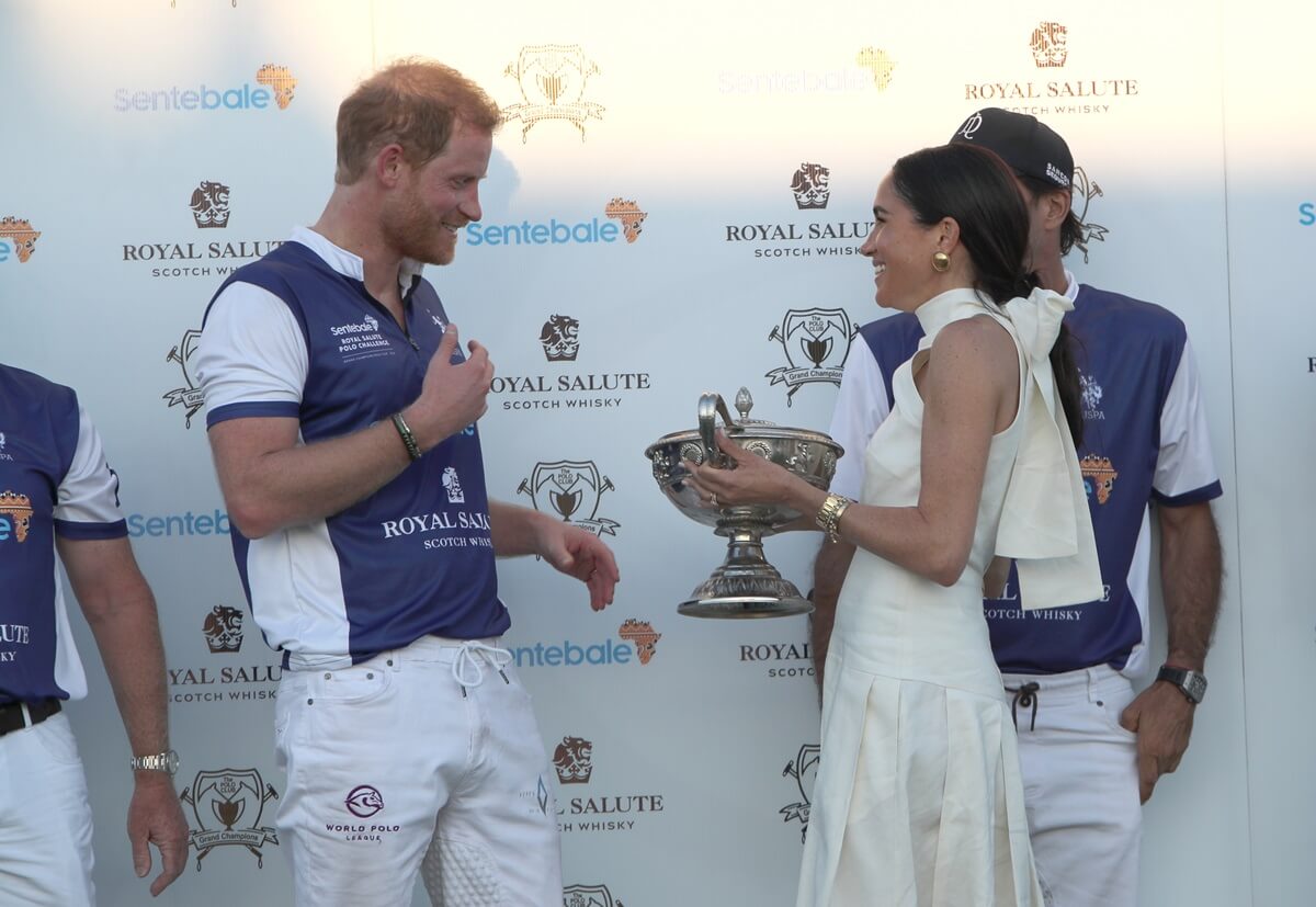 Meghan Markle presents trophy to Prince Harry after his team the Royal Salute Sentebale Team defeated the Grand Champions Team