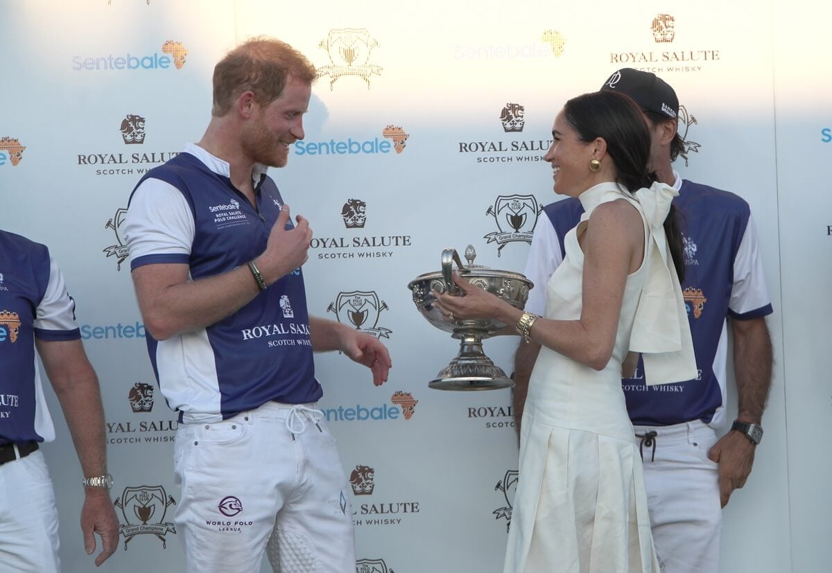 Meghan Markle presents trophy to Prince Harry after his team the Royal Salute Sentebale Team defeated the Grand Champions Team