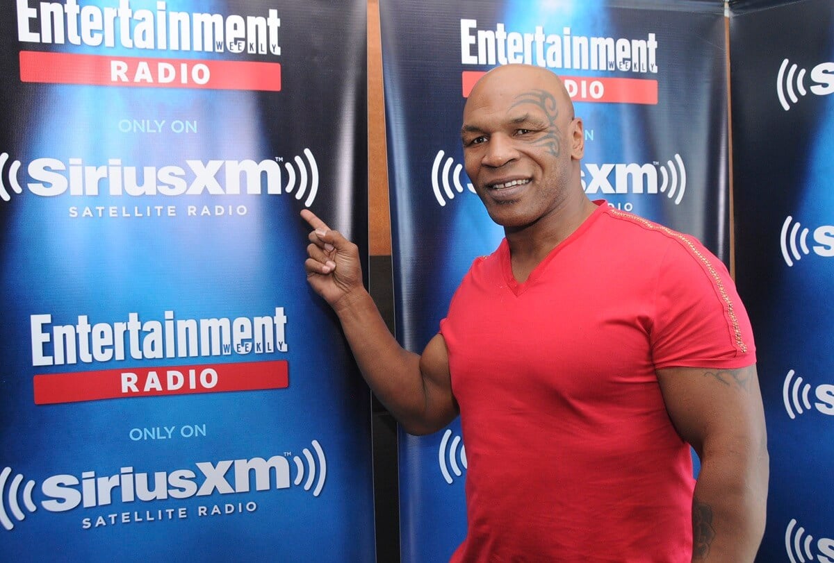 Mike Tyson posing in a red shirt.