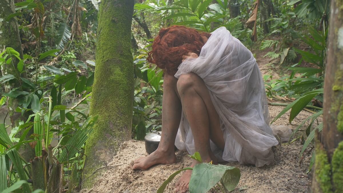 Fairland from 'Naked and Afraid' wrapped in a mosquito net with her head on her knees