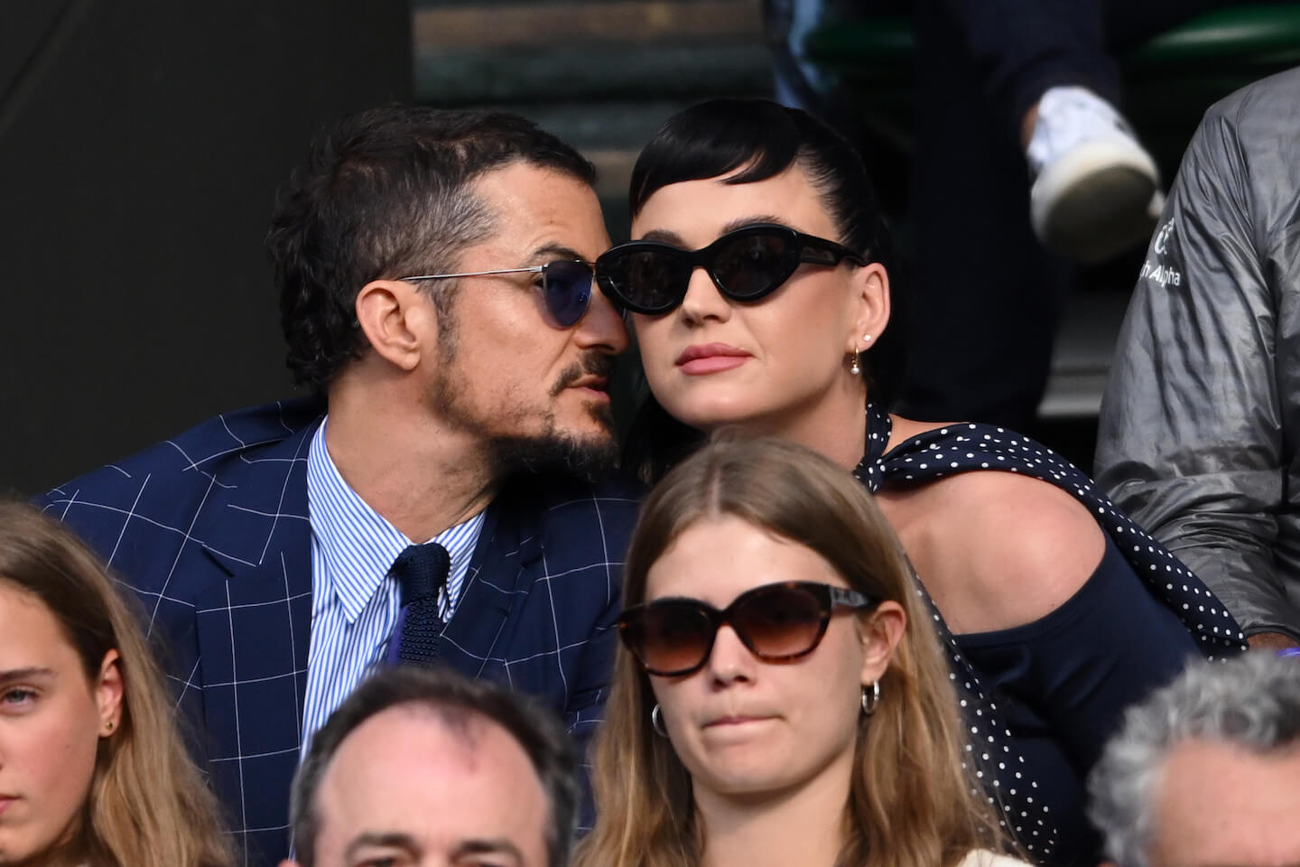 Orlando Bloom whispering into Katy Perry's ear at an event