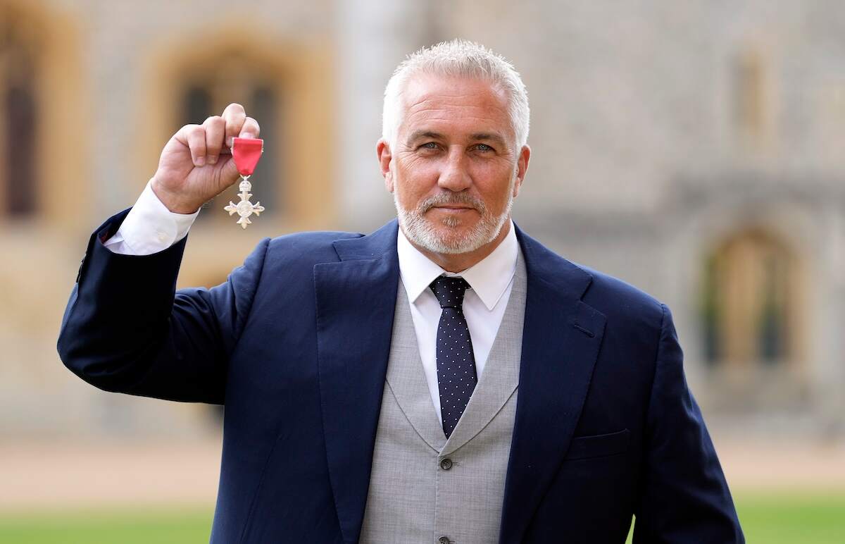 Celebrity chef Paul Hollywood holds up his medal after being made a Member of the Order of the British Empire