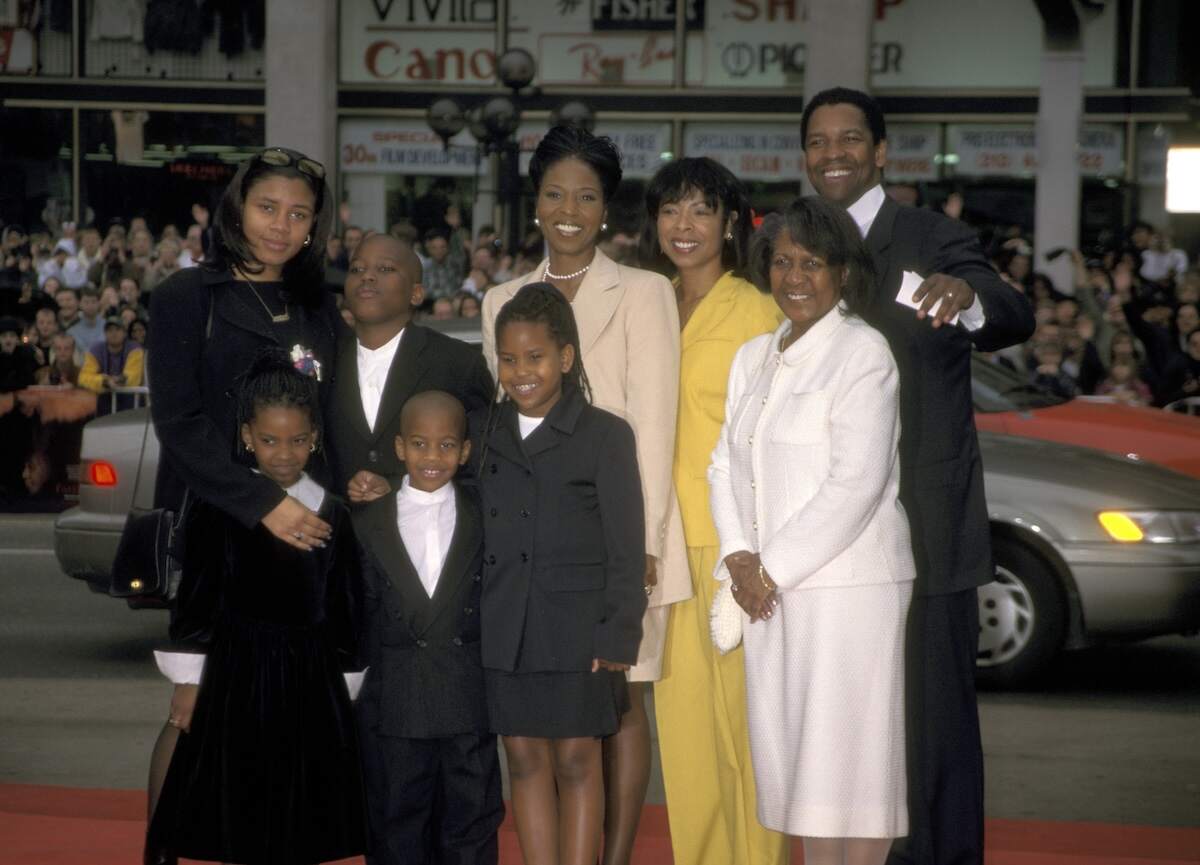 Actor Denzel Washington, Pauletta Washington, and their kids pose together on a red carpet in 1998
