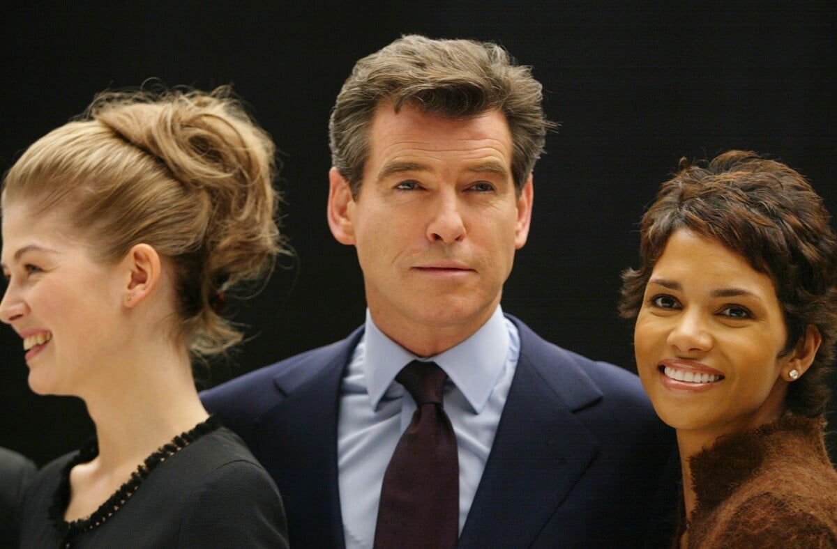 Pierce Brosnan posing in the middle of Bond girls Halle Berry and Rosamund Pike.