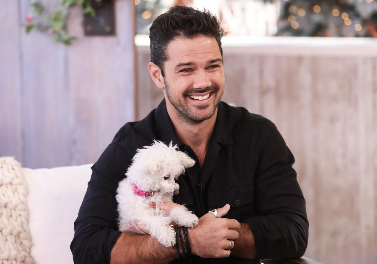 Ryan Paevey holding a small white dog