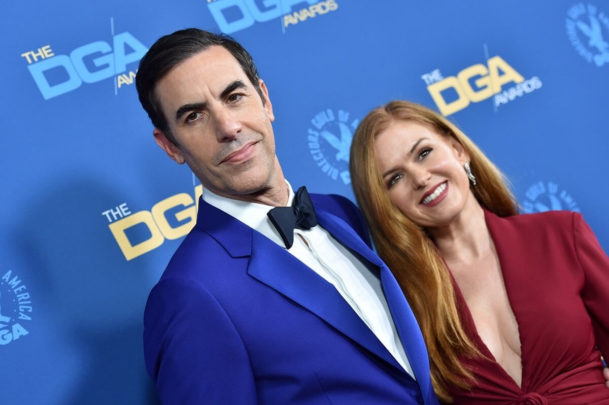 Sacha Baron Cohen in a blue suit posing next to Isla Fisher who's in a red dress at the 71st Annual Directors Guild of America Awards.