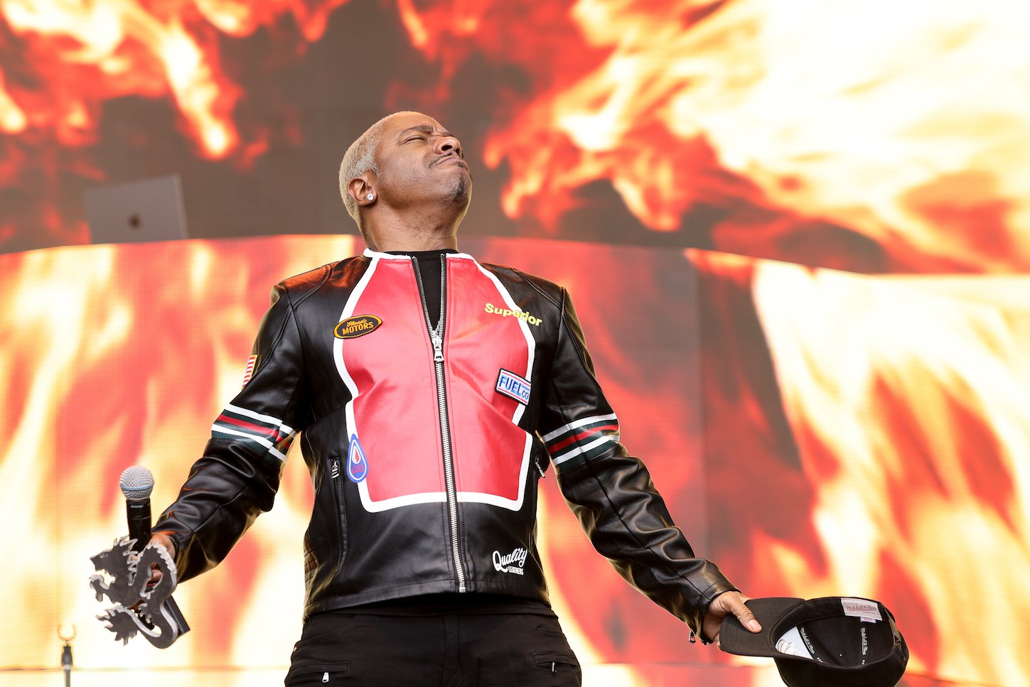 Sisqó of Dru Hill performing on stage in front of a firey background in 2023