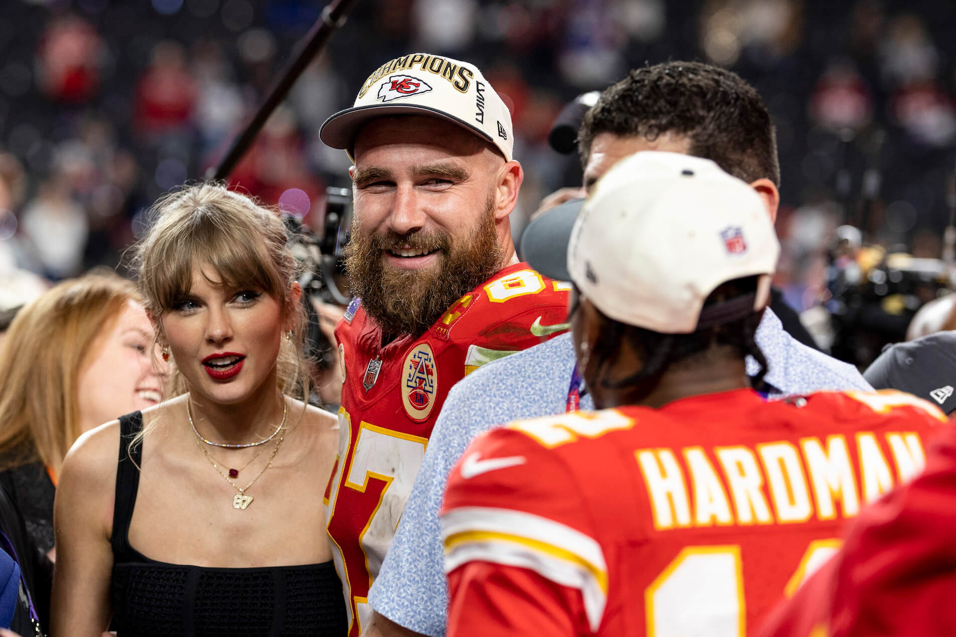 Taylor Swift standing next to Travis Kelce at a crowded Kansas City Chiefs game