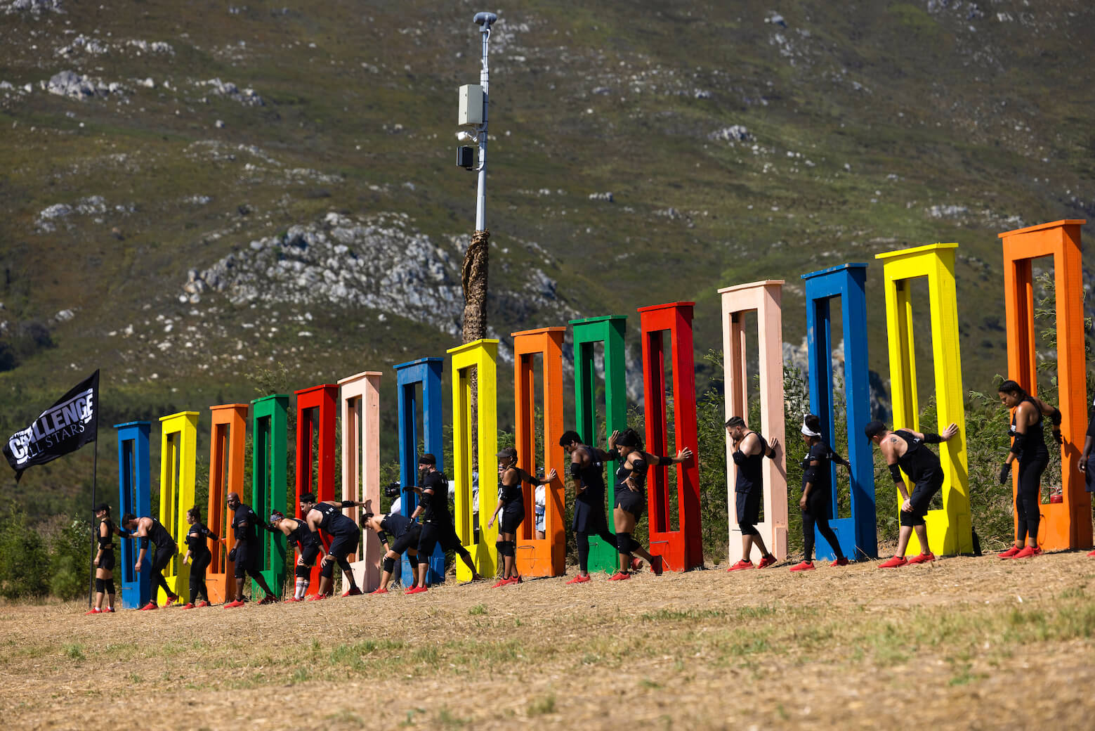 'The Challenge: All Stars' Season 4 cast members lining up against colorful structures during a challenge