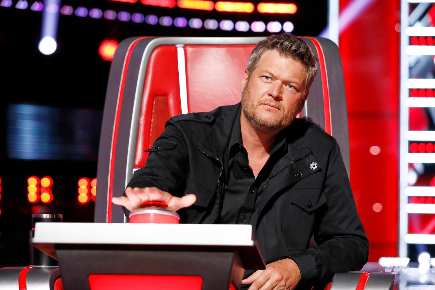 Blake Shelton sitting as a judge on 'The Voice' about to press the red button