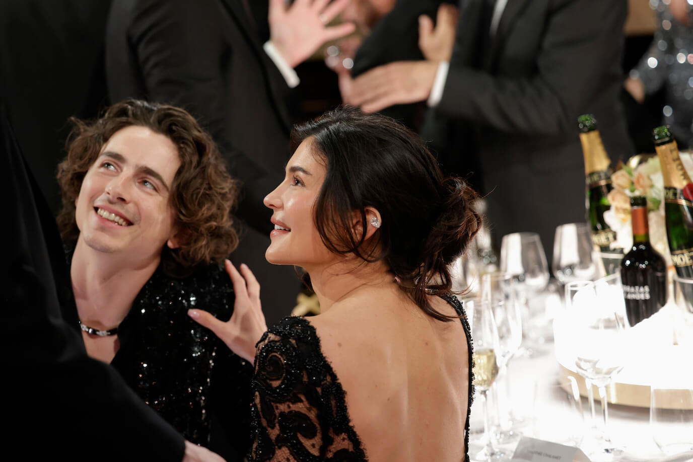 Timothée Chalamet smiling up at Julia Gardner at the Golden Globes. Kylie Jenner is also smiling with her hand on Chalamet's shoulder.