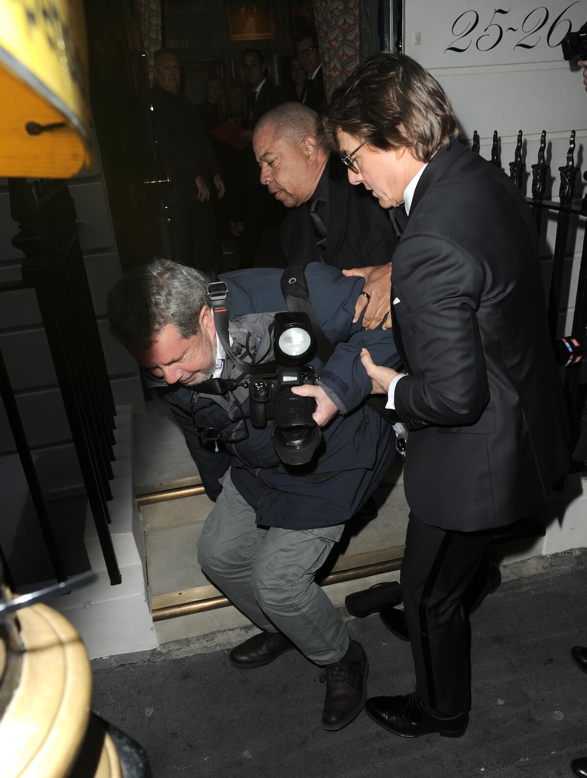 Tom Cruise helps a paparazzi who has stumbled