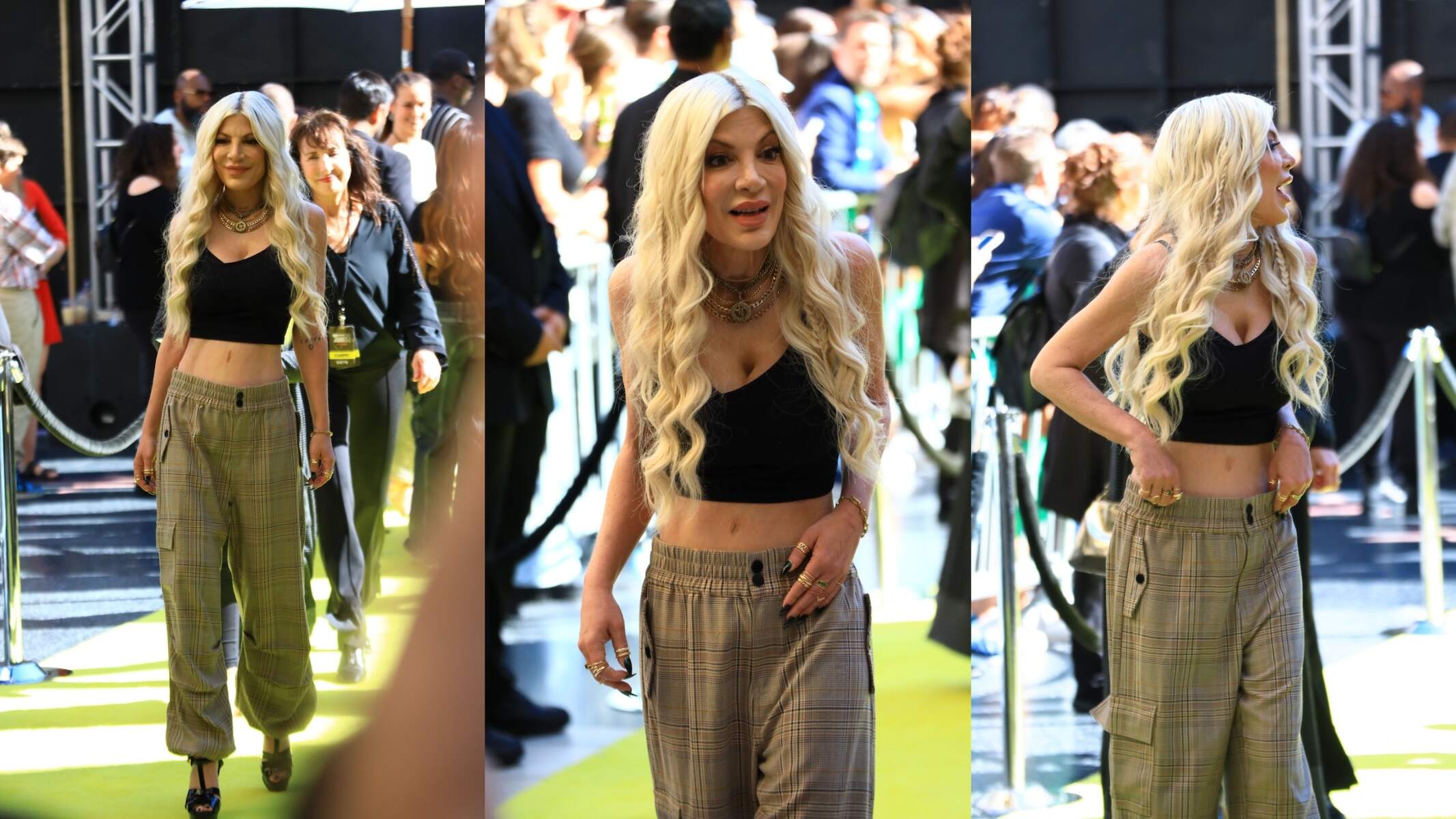 Wearing a black tank top and plaid pants, Tori Spelling smiles for cameras at the 2024 iHeartRadio Music Awards