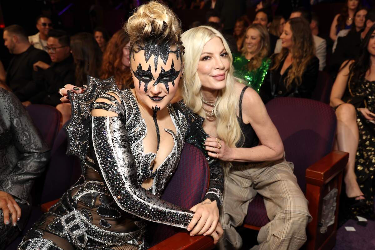 Celebrities JoJo Siwa and Tori Spelling smile for a photo together in the front seats of the 2024 iHeartRadio Music Awards