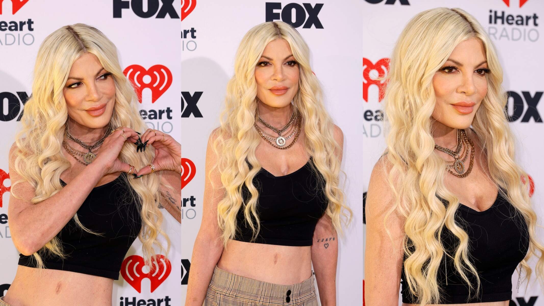 Wearing a black tank top and plaid pants, Tori Spelling smiles for cameras at the 2024 iHeartRadio Music Awards