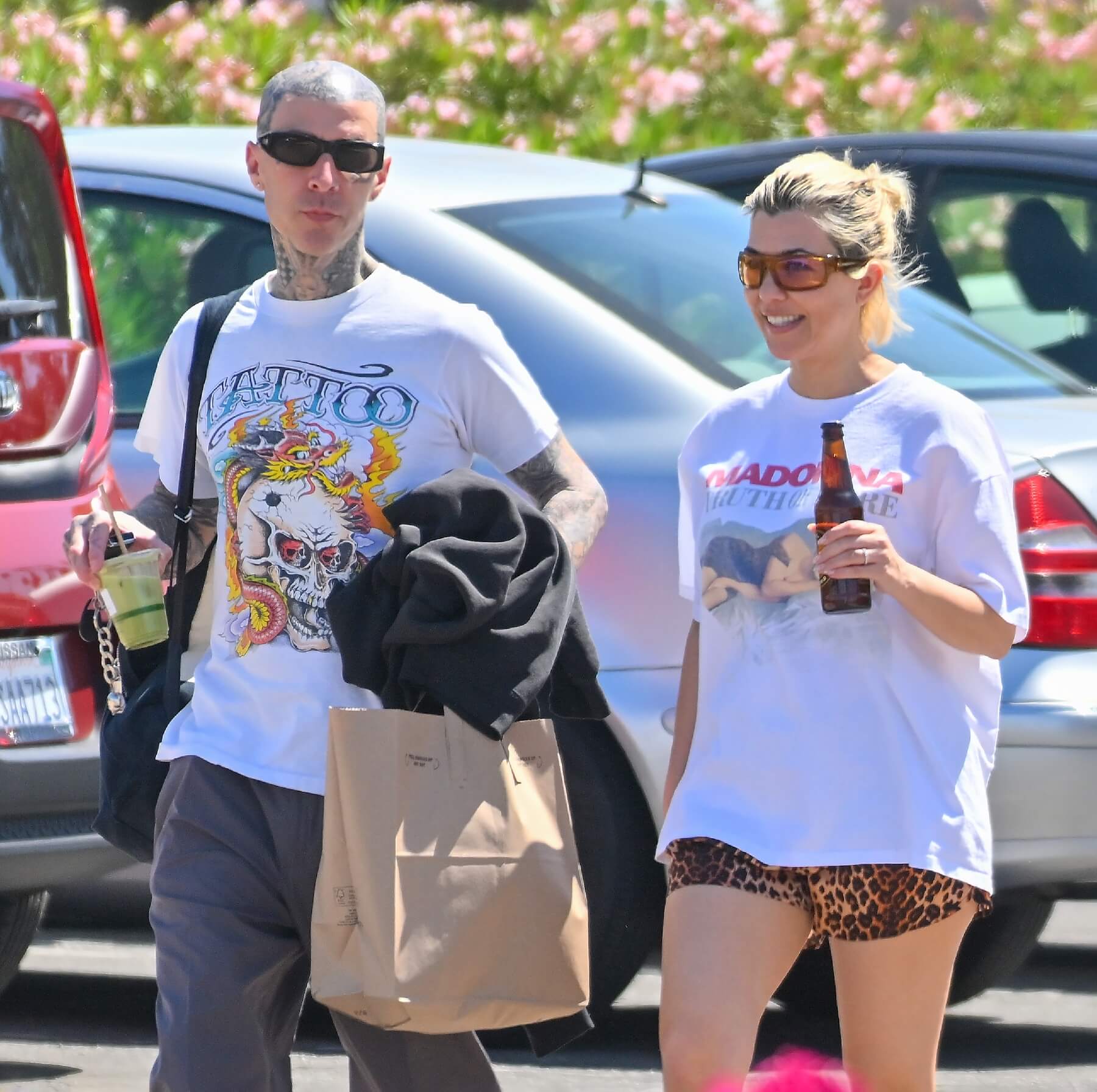 Travis Barker and Kourtney Kardashian walking together through a parking lot