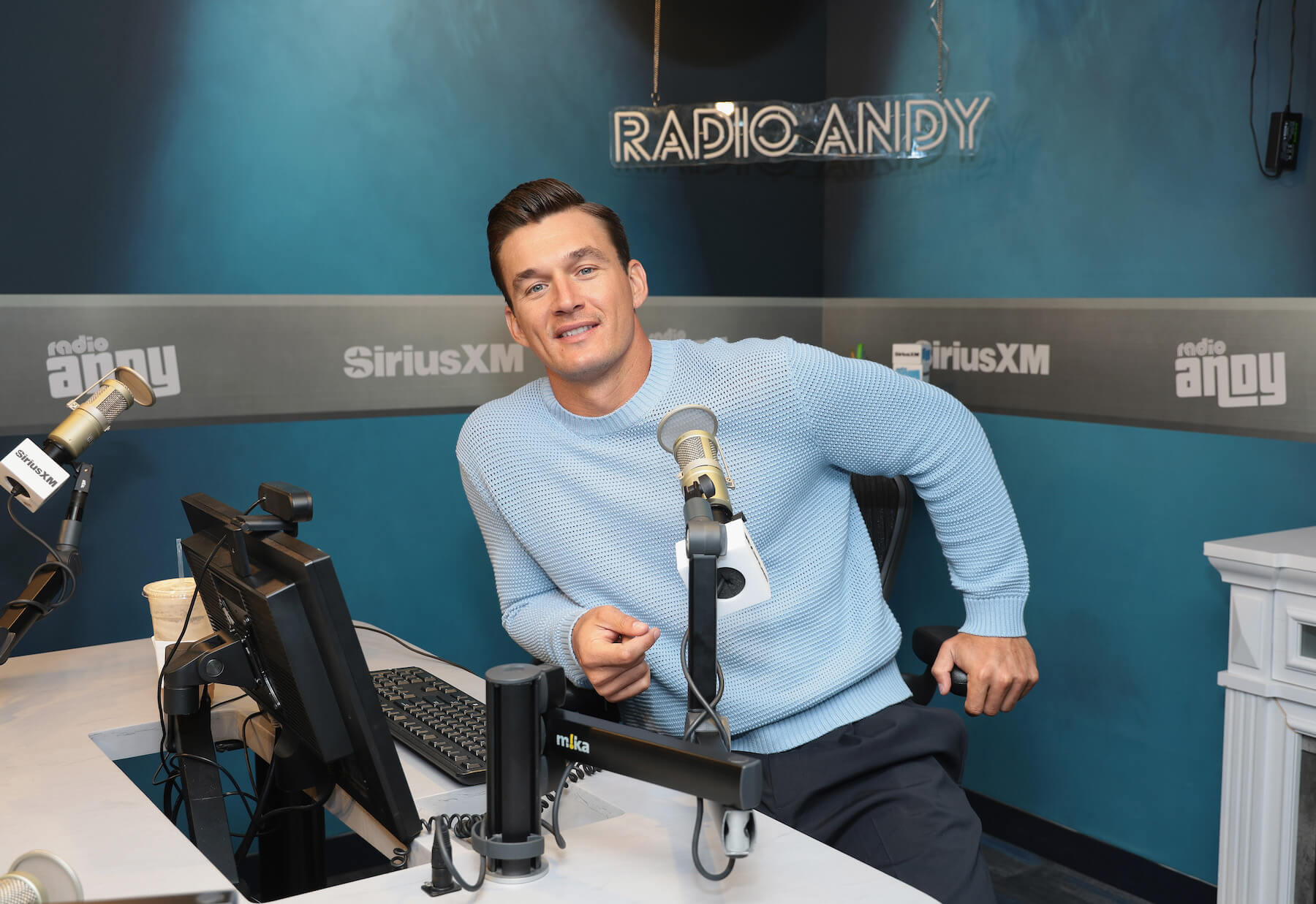 Bachelor Nation star Tyler Cameron smiling while on Radio Andy with SiriusXM. He discussed 'The Golden Bachelor' divorce.