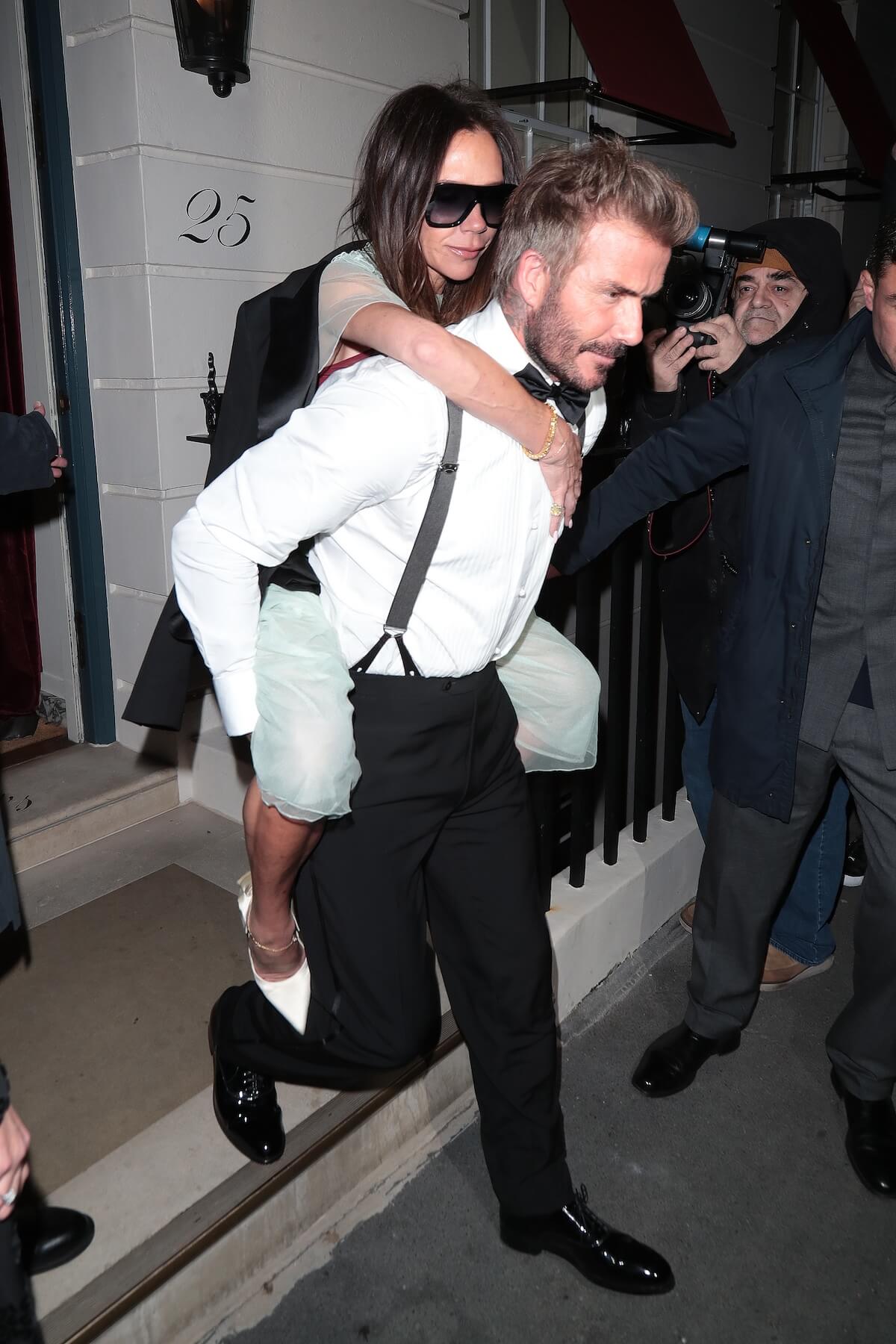 David Beckham carrying Victoria Beckham on his back