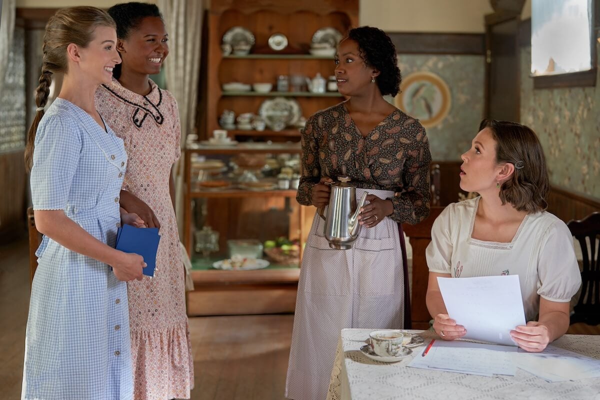 Allie and Angela standing in the cafe and talking to Minnie and Elizabeth in 'When Calls the Heart'